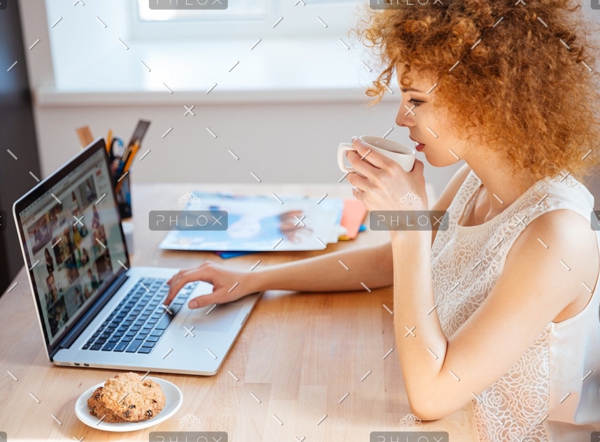 woman-photographer-drinking-coffee-and-working-PJNBP6U-2
